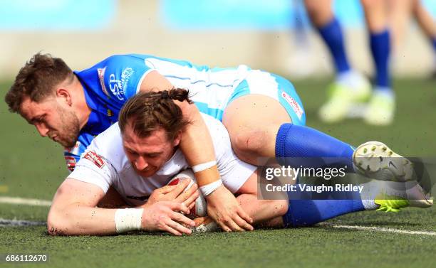 Andrew Dixon of Toronto Wolfpack scores a try as he is tackled by Lewis Charnock of Barrow Raiders in the first half of a Kingstone Press League 1...