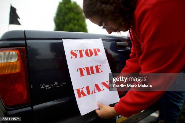 An activist affixes a protest poster against the Klu Klux Klan on his truck before driving in a caravan through the Quarryville area, where the KKK...