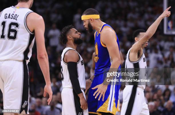 JaVale McGee of the Golden State Warriors exchanges words with Patty Mills of the San Antonio Spurs in the first half during Game Three of the 2017...