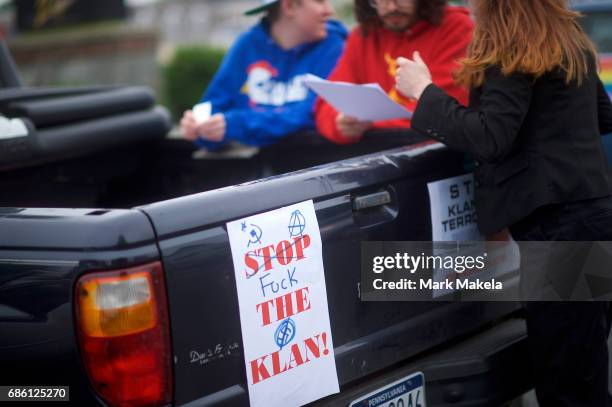 Activists gather to affix protest posters against the Klu Klux Klan to their cars before driving in a caravan through the Quarryville area, where the...