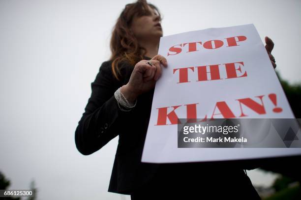 Carter Farmer prepares to affix a protest poster against the Klu Klux Klan to her car before driving in a caravan through the Quarryville area, where...