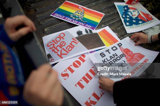 Activists gather to affix protest posters against the Klu Klux Klan to their cars before driving in a caravan through the Quarryville area, where the...