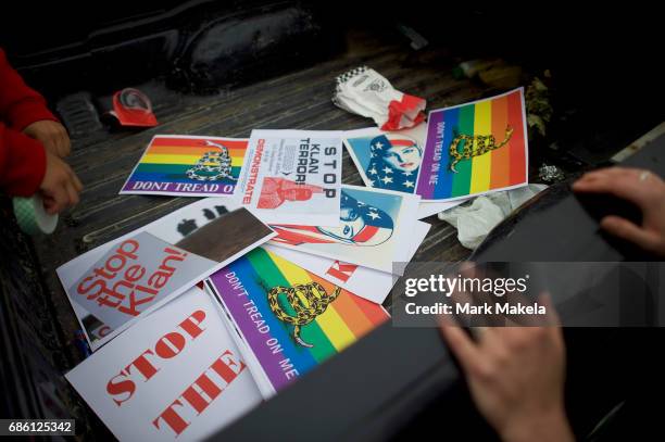 Activists gather to affix protest posters against the Klu Klux Klan to their cars before driving in a caravan through the Quarryville area, where the...