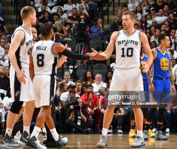 David Lee and Patty Mills of the San Antonio Spurs high five each other during the game against the Golden State Warriors during Game Three of the...