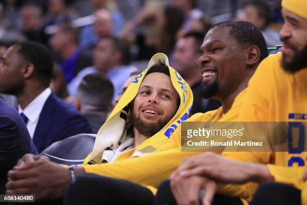 Stephen Curry and Kevin Durant of the Golden State Warriors react on the bench during the fourth quarter against the San Antonio Spurs during Game...
