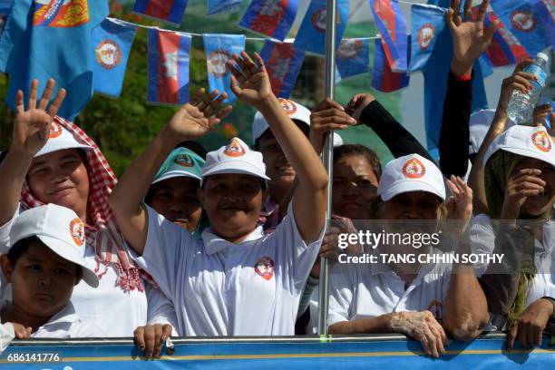 Supporters of Cambodian People Party stand on a truck during the Commune Election Campaign in Phnom Penh on May 21, 2017. Tuk-tuks blaring pop music...