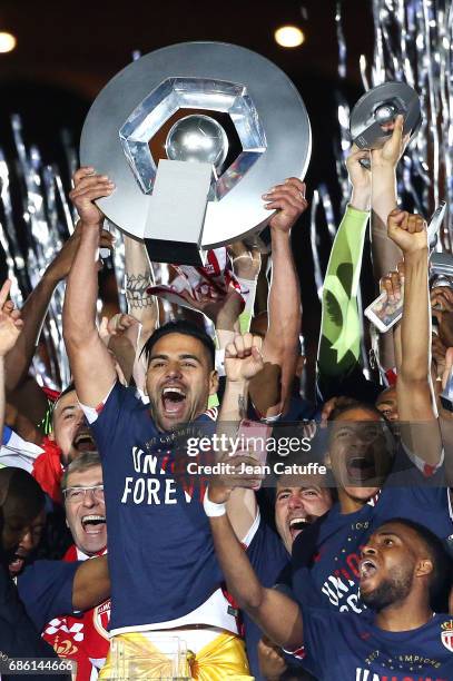 Radamel Falcao of Monaco holds the trophy between President of AS Monaco Dmitri Rybolovlev and Kylian Mbappe during the French League 1 Championship...