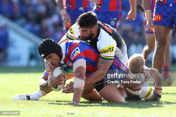 Sione Mata'Utia of the Knights is tackled by James Tamou of the Panthers during the round 11 NRL match between the Newcastle Knights and the Penrith...