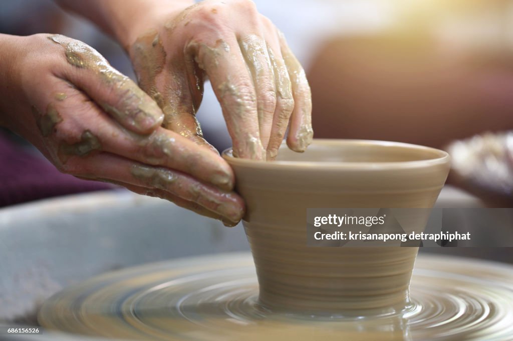 Closeup hands of a potter, creating an earthen jar on the traditional machine