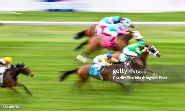 Slow shutter speed blurs the horses as they race on the turf during race six on the day during the 142nd running of the Preakness Stakes at Pimlico...