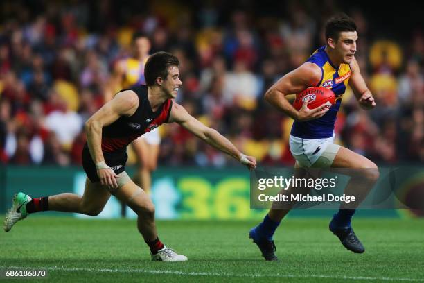 Sharrod Wellingham of the Eagles runs with the ball away from Zach Merrett of the Bombers during the round nine AFL match between the Essendon...