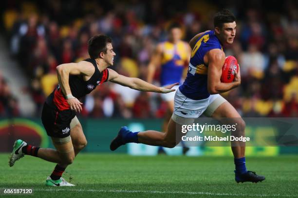 Sharrod Wellingham of the Eagles runs with the ball away from Zach Merrett of the Bombers during the round nine AFL match between the Essendon...