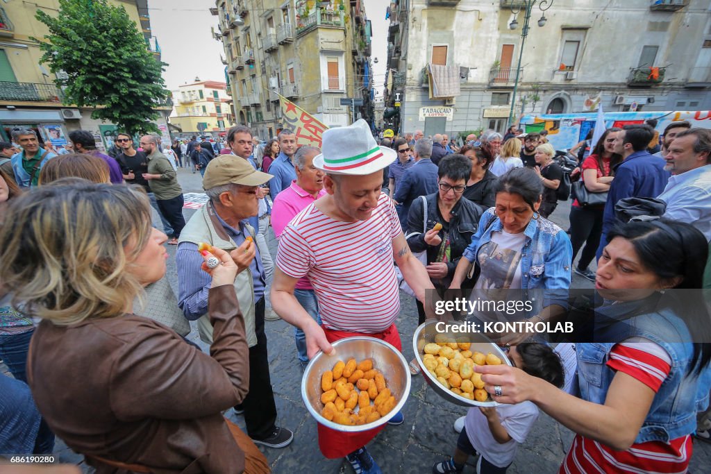 A pizzaiolo offers typical fried snacks to protesters during...