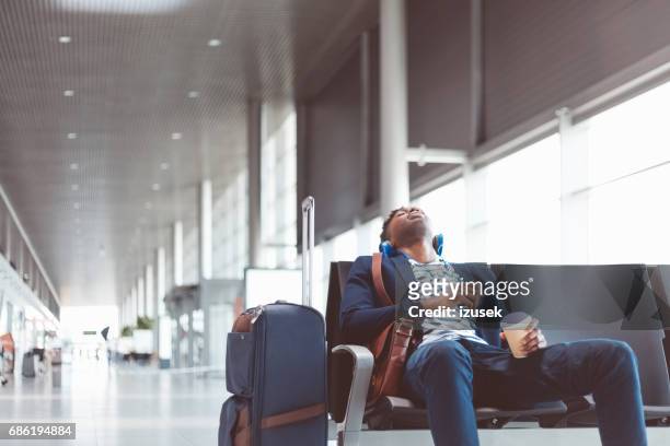 young traveler sleeping at airport waiting area - waiting imagens e fotografias de stock