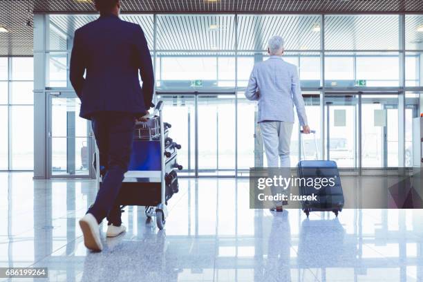 people with luggage walking to exit gates in airport - cartgate out stock pictures, royalty-free photos & images