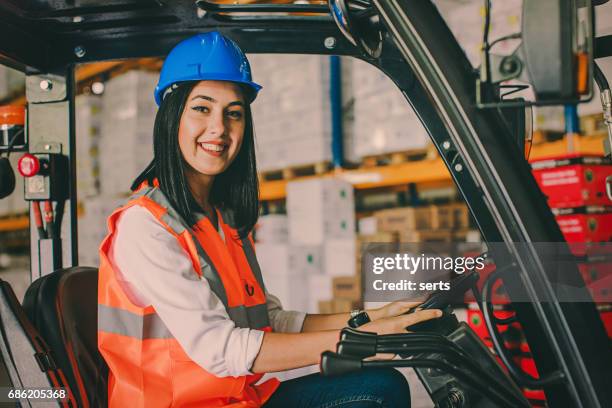 young woman driving a forklift at warehouse - pallet jack stock pictures, royalty-free photos & images