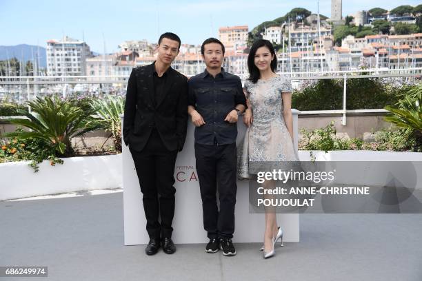 Chinese actor Yin Fang, Chinese director Li Ruijun and Chinese actress Yang Zishan pose on May 21, 2017 during a photocall for the film 'Walking past...