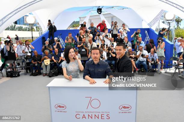 Chinese actress Yang Zishan, Chinese director Li Ruijun and Chinese actor Yin Fang pose on May 21, 2017 during a photocall for the film 'Walking past...