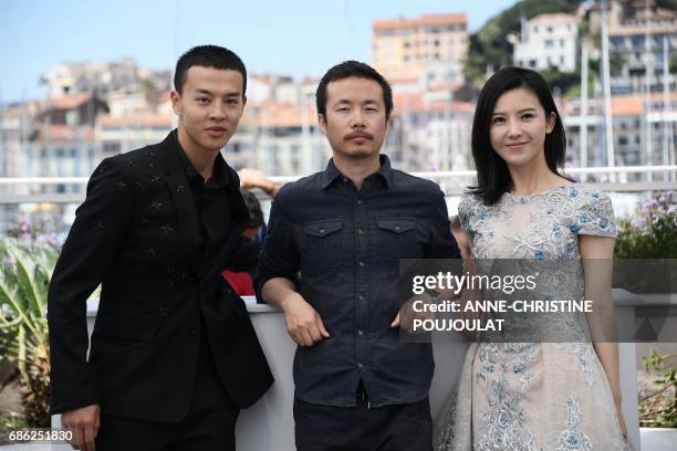 Chinese actor Yin Fang, Chinese director Li Ruijun and Chinese actress Yang Zishan pose on May 21, 2017 during a photocall for the film 'Walking past...