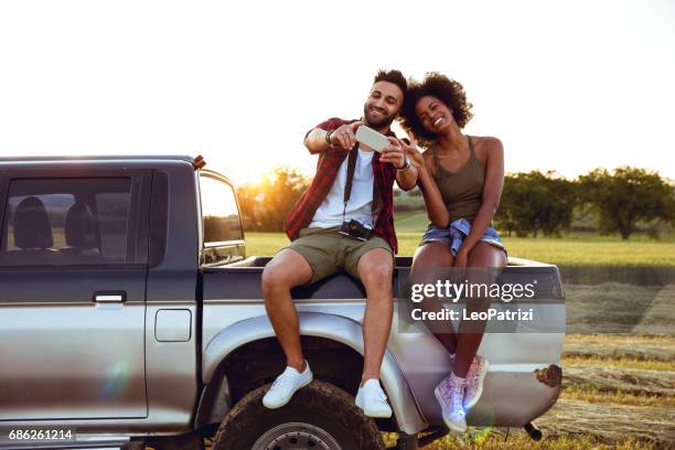giovani amici che si godono la libertà in un viaggio in auto su un fuoristrada di campagna - generazione y foto e immagini stock