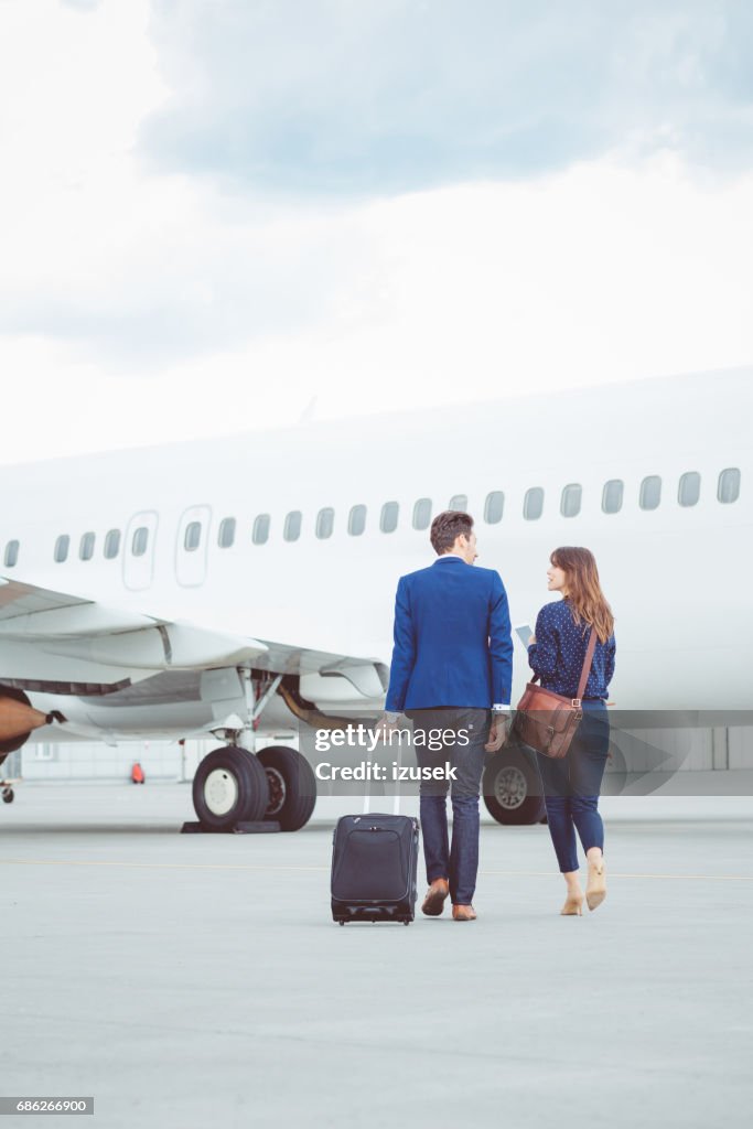 Business colleagues walking on tarmac at the airport