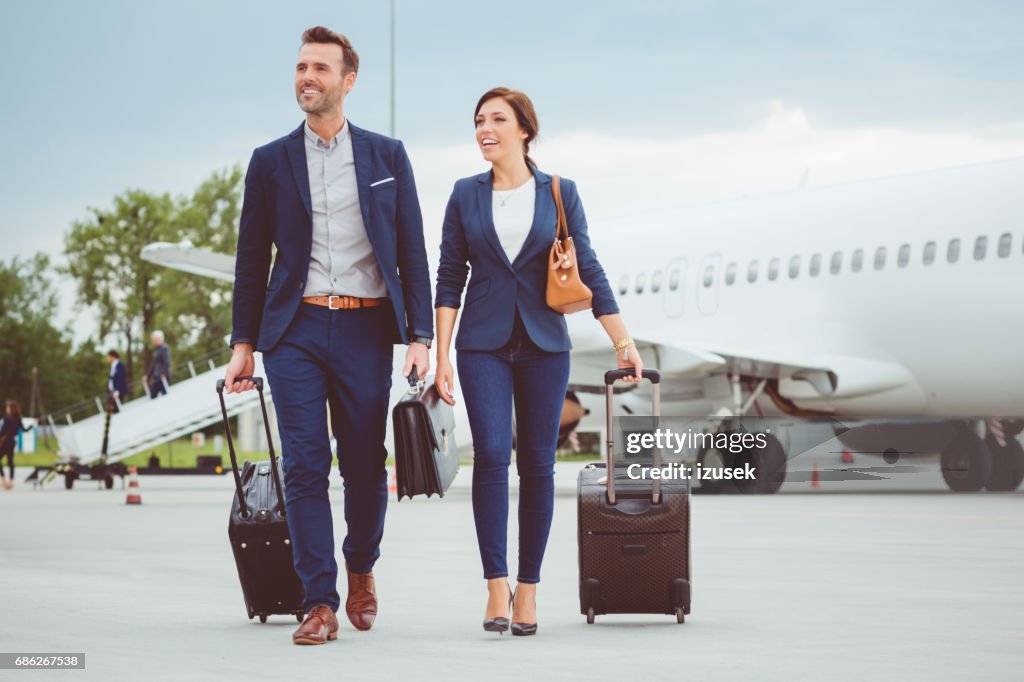 Junge Geschäftsleute zu Fuß vor Flugzeug