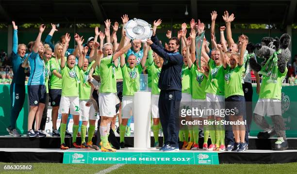Nilla Fischer of VfL Wolfsburg and head coach Ralf Kellermann of VfL Wolfsburg lift the Championship trophy in celebration of the German Championship...