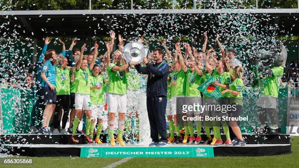 Nilla Fischer of VfL Wolfsburg and head coach Ralf Kellermann of VfL Wolfsburg lift the Championship trophy in celebration of the German Championship...