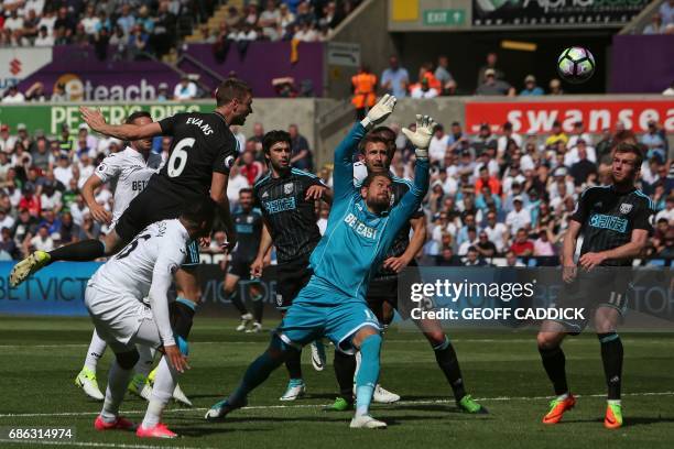 West Bromwich Albion's Northern Irish defender Jonny Evans jumps to head the ball past Swansea City's Swedish goalkeeper Kristoffer Nordfeldt to...