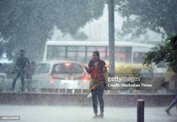 People caught in a sudden heavy rainfall and dust storm at Connaught Place, on May 21, 2017 in New Delhi, India. Heavy rainfall lashed Delhi/NCR...