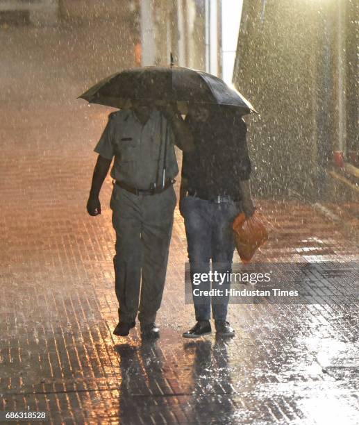 People caught in a sudden heavy rainfall and dust storm at Connaught Place, on May 21, 2017 in New Delhi, India. Heavy rainfall lashed Delhi/NCR...