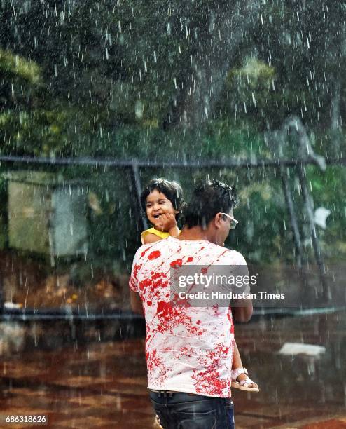 People caught in a sudden heavy rainfall and dust storm at Connaught Place, on May 21, 2017 in New Delhi, India. Heavy rainfall lashed Delhi/NCR...