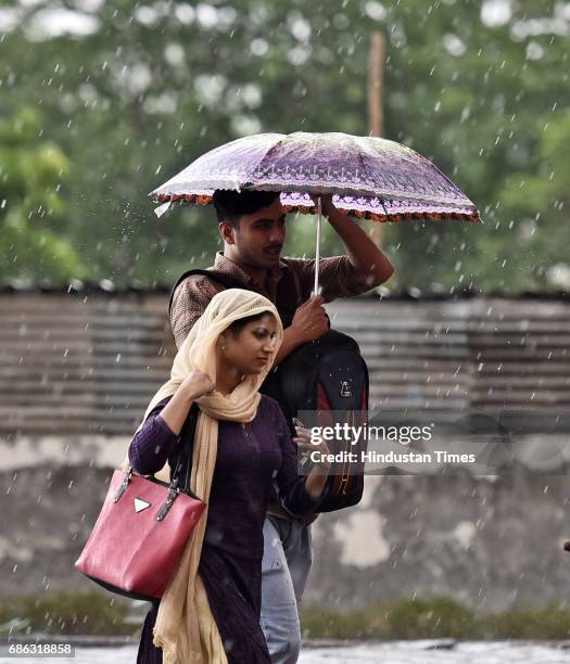 People caught in a sudden heavy rainfall and dust storm at MG Road, on May 21, 2017 in Gurugram, India. Heavy rainfall lashed Delhi/NCR evening...