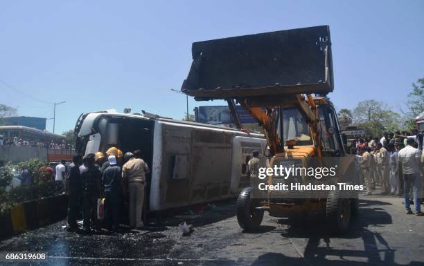 Fire personnel, Police personnel and bystander helping in rescuing passenger after a Private bus transporting people for reception from Malad to...