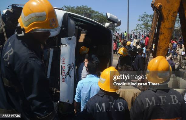 Fire personnel, Police personnel and bystander helping in rescuing passenger after a Private bus transporting people for reception from Malad to...