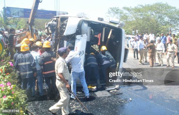 Fire personnel, Police personnel and bystander helping in rescuing passenger after a Private bus transporting people for reception from Malad to...