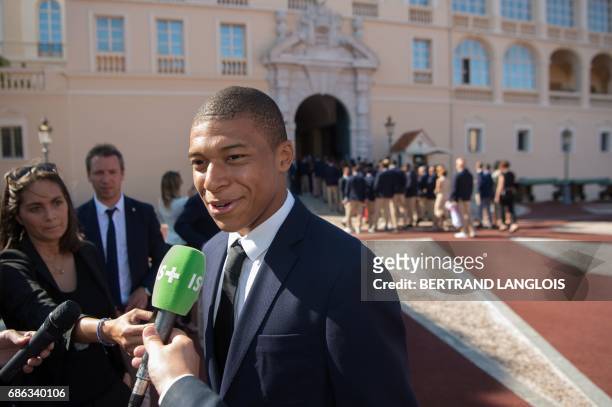 Monaco's French forward Kylian Mbappe speaks to journalists as hes arrives at the Prince's Palace in Monaco on May 21 to attend celebrations to mark...