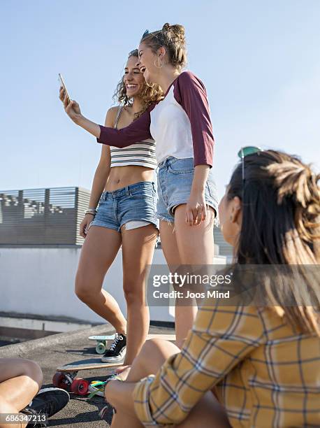 teenage skateboarders taking selfie on rooftop - crop top stock pictures, royalty-free photos & images