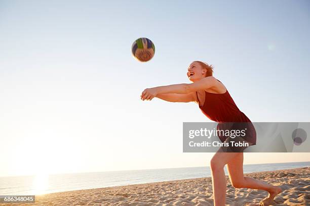 teenage girl hitting volleyball at the beach - beach volleyball - fotografias e filmes do acervo