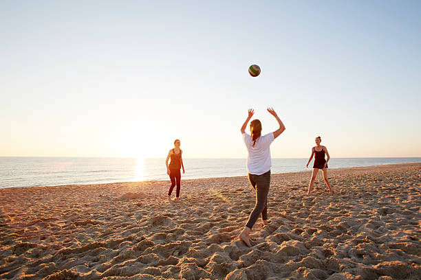 girls playing volleyball at the beach - girls volleyball stock pictures, royalty-free photos & images