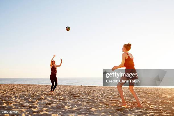 women playing volleyball at the beach - girls beach volleyball stock pictures, royalty-free photos & images