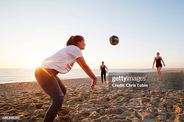 girls playing beach volleyball - beach sports stock-fotos und bilder