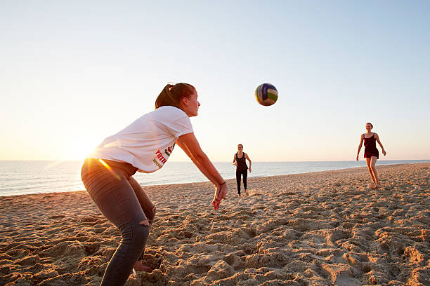 girls playing beach volleyball - girls volleyball stock pictures, royalty-free photos & images