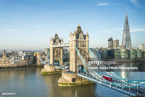 tower bridge and the river thames in london. - london buses stock-fotos und bilder