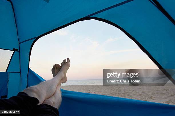 feet sticking out of tent at beach - 足首を重ねる ストックフォトと画像