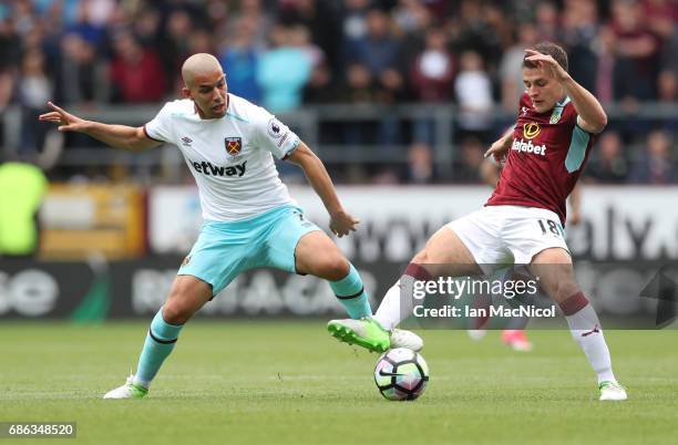 Sofiane Feghouli of West Ham United vies with Ashley Westwood of Burnley during the Premier League match between Burnley and West Ham United at Turf...