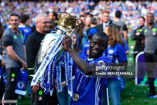 Chelsea's French midfielder N'Golo Kante poses with the English Premier League trophy, as players celebrate their league title win at the end of the...