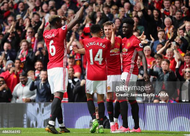 Josh Harrop of Manchester United celebrates with his team mates after scoring a goal to make it 1-0 during the Premier League match between...