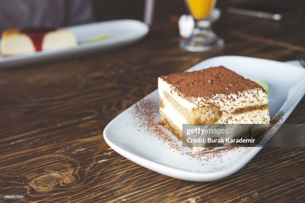 Tiramisu on the plate on the wooden background