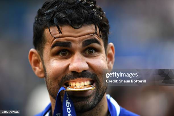 Diego Costa of Chelsea bites his Premier League winners medal after the Premier League match between Chelsea and Sunderland at Stamford Bridge on May...